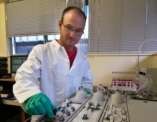 A male scientist operating an instrument.